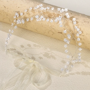 Detailed view of silver wire bridal headband with delicate white floral clusters and ribbon