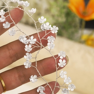 Close-up of handmade white floral bridal headband with silver wire and crystals