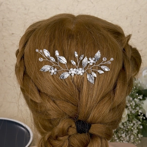 Elegant bridal hair comb with silver leaves, pearls and crystals on braided brown hair