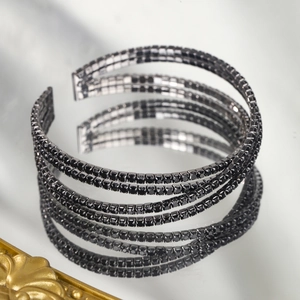 Détail du bracelet ouvert multicouche avec strass noirs et finition polie brillante