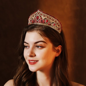 Detail of luxury bridal crown with red teardrop crystals and gold alloy finish on model