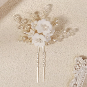 Vue détaillée de fleurs en argile faites main avec perles et cristaux sur épingle à cheveux