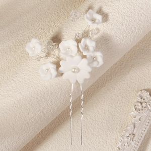 Détail de fleurs en argile blanche et perles sur épingle à cheveux de mariée en fil d'argent