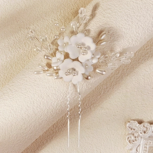 Détail de fleurs en argile faites main avec perles et cristaux sur une épingle de mariée
