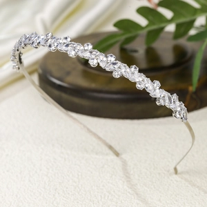 Elegant thin silver headband with marquise cubic zirconia crystals on a wooden pedestal
