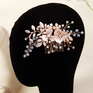 Détail d'un peigne à cheveux de mariée doré rose avec perles et cristaux sur modèle