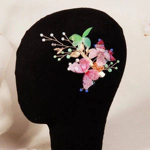 Detailed shot of handmade butterfly hair clip with pink tulle and pearl beads on a model