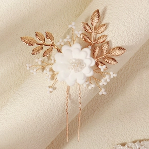 Detailed view of handmade golden leaf and white flower bridal hair pin with pearls
