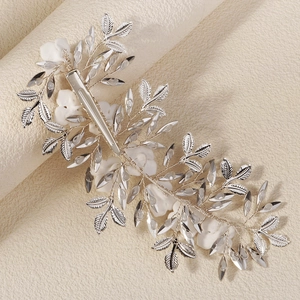 Elegant bridal hair clip featuring silver metal leaves and white ceramic flowers on ivory background