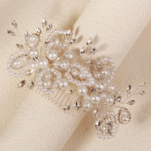 Vue détaillée d'un peigne à cheveux de mariée avec perles et strass sur fond beige