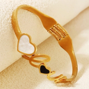 Dettaglio del bracciale a molla dorato con design LOVE, madreperla e intarsi a cuore nero