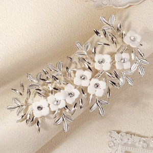 Elegant bridal hair clip with white matte flowers and silver metallic leaf designs