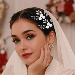 Detail of bridal hair pin with white ceramic flowers and silver rhinestone accents