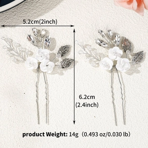 Detail view of handmade ceramic flower hair pin with rhinestones and silver leaves