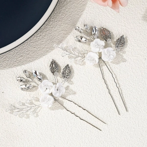 Detail view of handmade bridal hair pins with white ceramic flowers and crystal beads