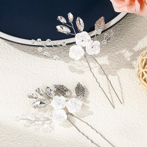 Detail of handmade ceramic flower hair pin with sparkling crystals and silver wire leaves