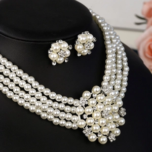 Gros plan sur le collier de perles à quatre rangs et boucles d'oreilles fleuries en strass