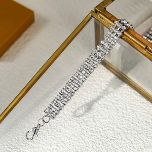 Détail d'un bracelet à trois rangées de strass argenté avec un fermoir mousqueton