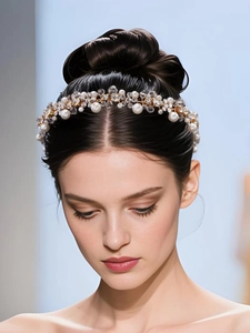 Vue détaillée d'un serre-tête de mariée avec perles blanches et cristaux sur monture dorée