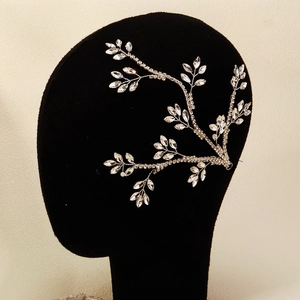 Macro detail of bridal hair piece showing silver vine design with sparkly rhinestones