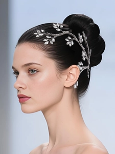 Detail of silver bridal hair vine with shimmering crystal leaves on a branch design