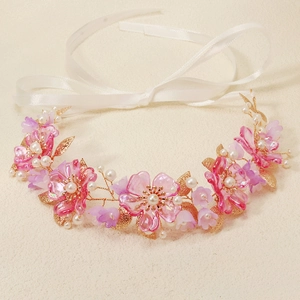 Detailed close-up of pink resin flowers and white pearls on a bridal floral headband