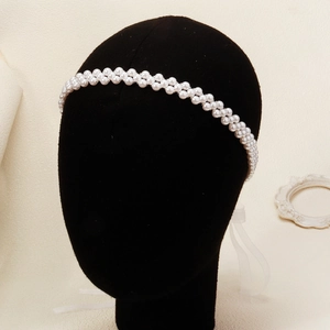 Dettaglio della fascia da sposa con perle bianche e nastri di seta eleganti e lucidi