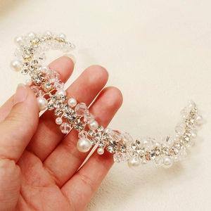 Détail d'un serre-tête de mariée fait main avec perles blanches et cristaux brillants