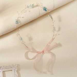 Detailed view of handmade bridal headband with blue resin flowers and white pearls