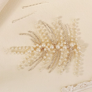 Detailed macro view of handmade bridal hairband with white pearls and silver leaf accents