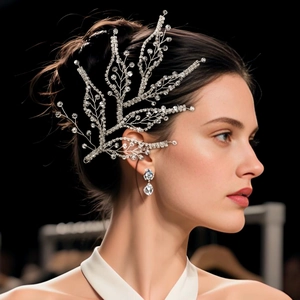Detailed close-up of crystal leaf bridal headpiece with silver rhinestones on a model