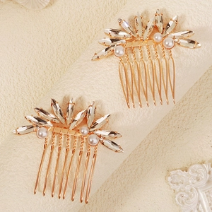 Dettaglio di due pettini per capelli dorati con cristalli marquise e perle bianche