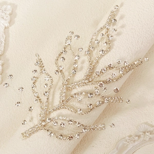 Macro detail of silver leaf bridal headband with sparkling crystal rhinestones on fabric
