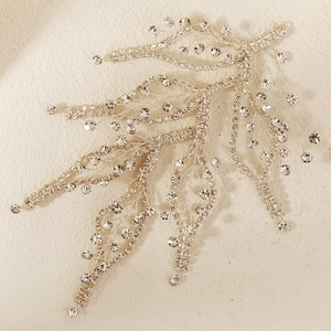 Macro shot of silver bridal hair vine with crystal leaves and rhinestone branches