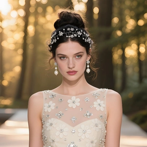 Detailed view of silver bridal headband with pearls and matching earrings on a model