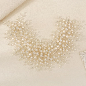 Detailed macro view of handmade bridal hairband with intricate pearls and silver vine wire