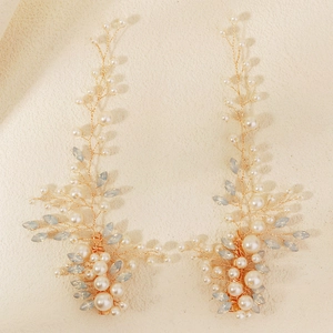 Macro detail of handmade bridal hair clips with pearls and blue crystals in plant branch style