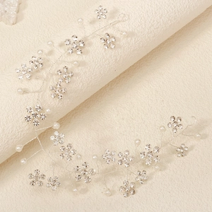 Detail of silver bridal headband with sparkling rhinestones and white pearls on leather