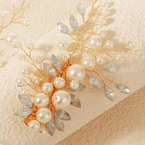 Detail of bridal hair clip with gold wires, white pearls and blue crystal leaves