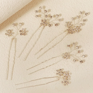 Detail of 5-piece silver bridal hair pins with sparkling crystals in a floral U-shape design