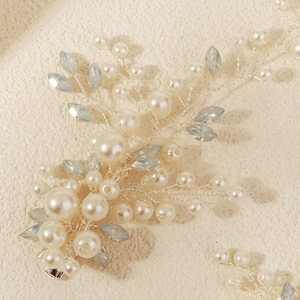 Detail of bridal hair clip with silver wire, white pearls and blue crystal leaves