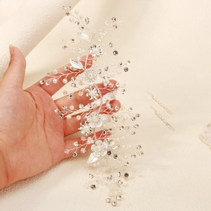 Detailed macro of silver bridal hair vine with white pearls and sparkling rhinestones