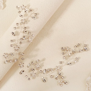 Detail of bridal headband with shimmering crystals, white pearls and floral metal weaving