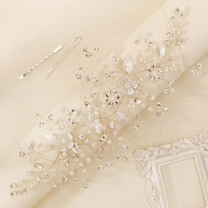 Detail of bridal hair vine with white enamel flowers, pearls and crystal leaves