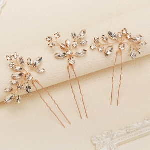 Detail of three bridal hair pins with marquise rhinestones and handmade gold wire leaves