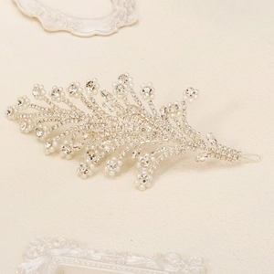 Detail of bridal hairband with leaf shaped rhinestones and pearls on silver metal base