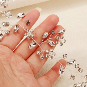 Close-up of bridal headband with sparkling rhinestones and white pearls on silver wire
