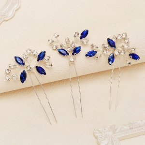Flat lay of three U-shaped hair pins with blue marquise crystals in flower design