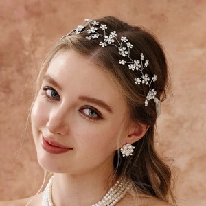 Detail of bridal hair vine featuring white flowers, rhinestones and matching jewelry