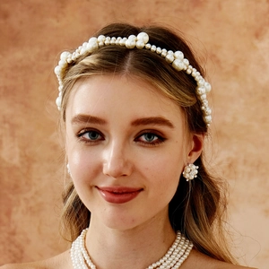 Close-up of elegant pearl bridal headband and matching earrings on a female model